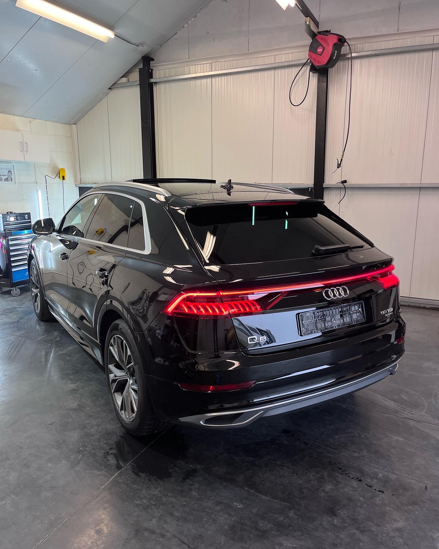 Audi Q8 geparkeerd in de garage waarvan de achterruit getint is