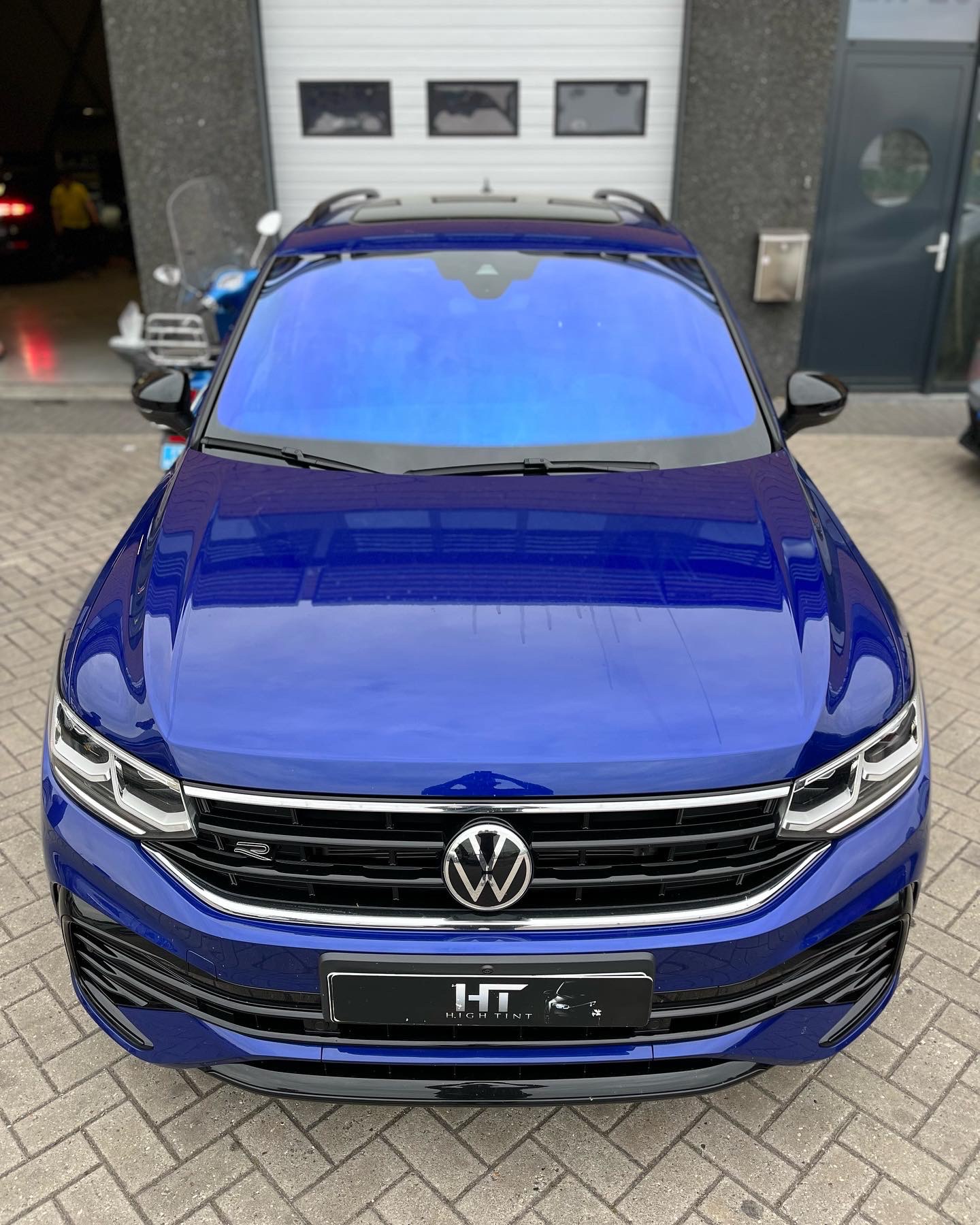Volkswagen Tiguan R 2020 geparkeerd voor een drukke garage